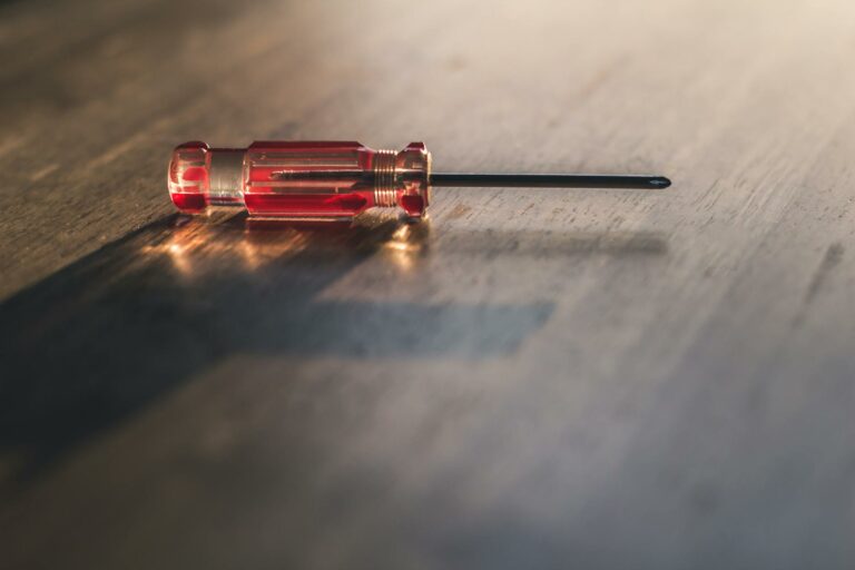 Red Screw Driver on Brown Wooden Surface